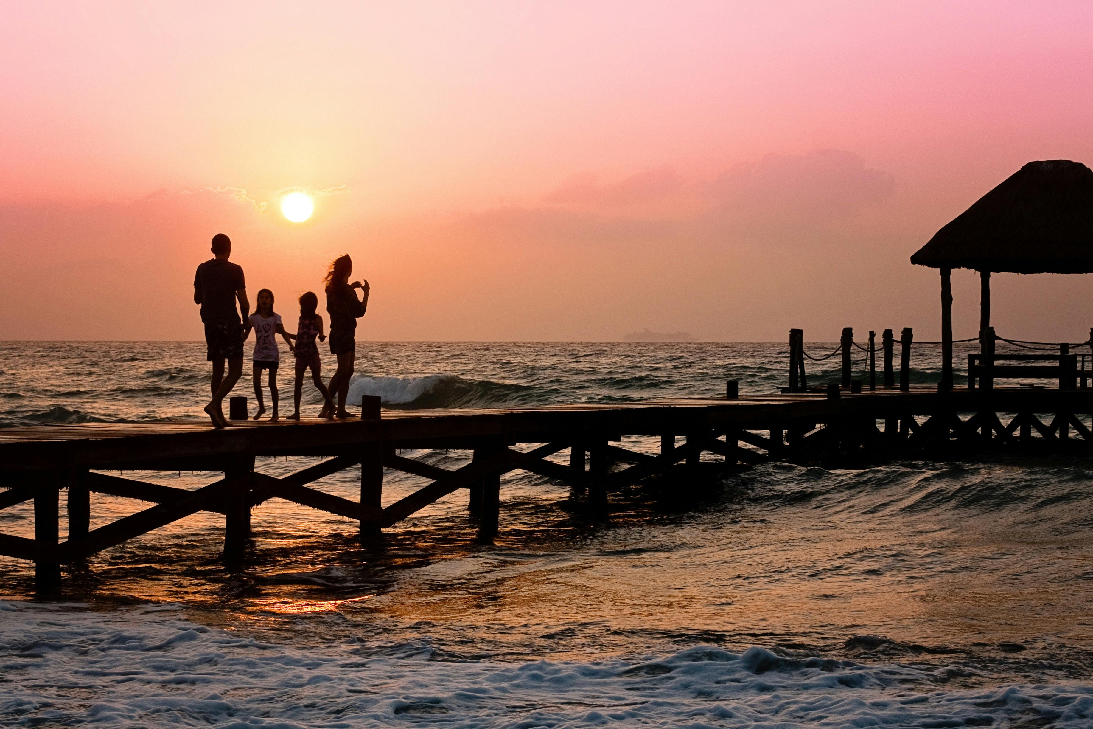 Family watching the sunset on a jetty